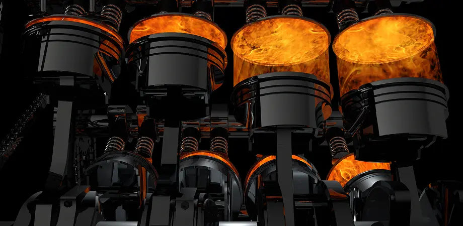 Close-up of multiple glowing orange pistons in engine in a dark setting