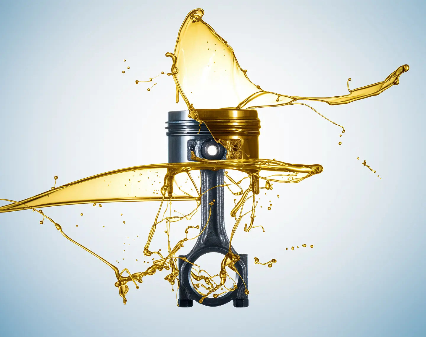 Piston with oil splashes on a light blue background